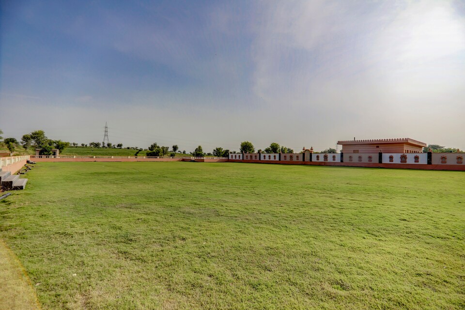 Expansive Front Green Wedding Lawn enclosed by pink sandstone jharokha walls at Sri Karni Heritage Resort
