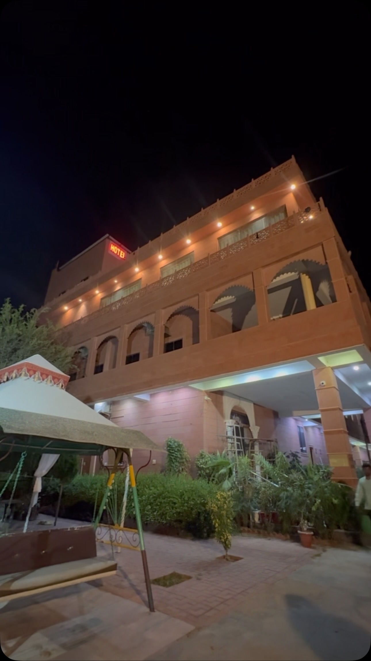 Sri Karni Heritage Resort illuminated sandstone facade at night with scalloped Rajasthani arches